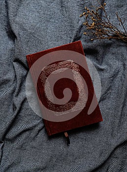 Old book cover in red canvas with embossed golden abstract decorations.