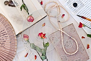 Old book and dry rose and accessories for writing.