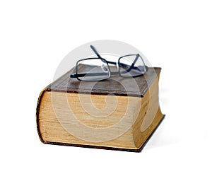 Old, book and glasses with ancient manuscript for knowledge, literature or history on a white studio background. Closeup