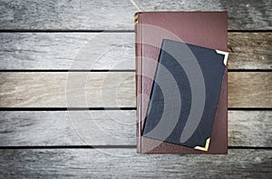 Old book with leather cover on vintage wooden floor background