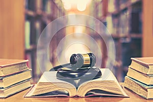 Old book in library with judge gavel on open law textbook in court archive text collection study room for copyrights day photo