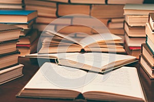 Old book in library with open textbook, stack piles of literature text archive on reading desk in school study class room