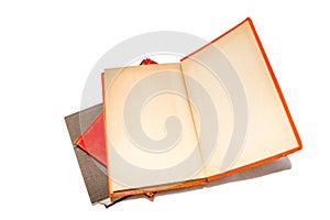 Old book lying open on a stack of other old books with yellowed inside of cover and fly leaf blank for text - isolated on white