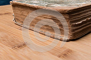 Old book open on a wooden table with glasses