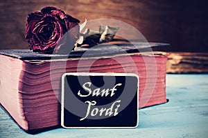 Old book, rose and text Sant Jordi