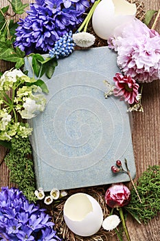 Old book among spring flowers