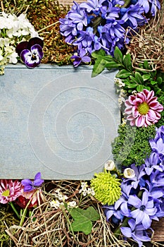 Old book among spring flowers, copy space
