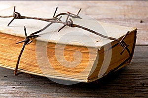 Old book wrapped with rusty barbed wire