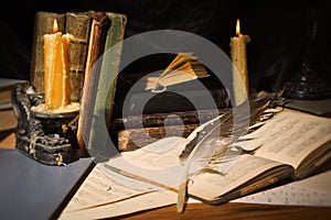 Old books and candles on wooden table