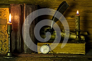 Old books, clocks, burning candles and scrolls of documents lie on the table