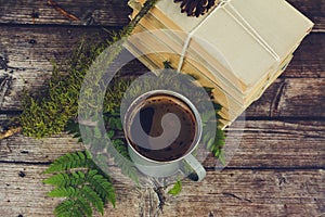 Old books and cup of coffee on dark wooden background