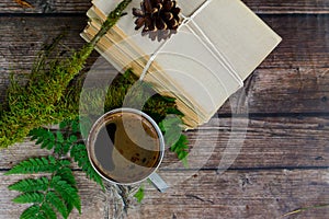 Old books and cup of coffee on dark wooden background