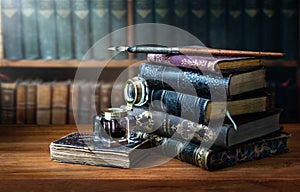 Old books , Fountain pen and vintage inkwell in old library. Conceptual background on history, education, ancient, literature photo