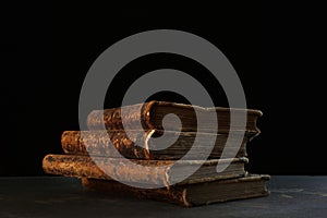 Old books. Four volumes of old books on a black background. The concept of knowledge and collecting. The old library