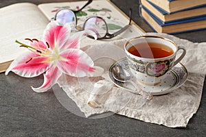 Old books and mail with antique cup of tea