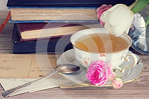 Old books and mail with cup of tea