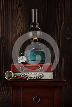 Old books, oil lamp and vintage watch on a chain