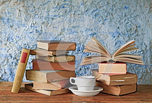 Old books, one open and a cup of coffee