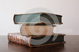 Old books piled on an antique wooden table
