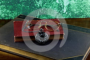 Old Books with Pocket Watch and Spectacles on a Wooden Table Top