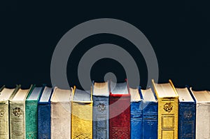 Old Books In A Row In Library On Black Background With Copy-Space