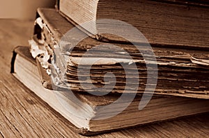 Old books on a rustic wooden table, sepia toning