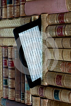 Old books on the shelf with a tablet in between