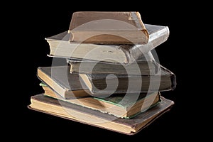 old books stacked one on top of another on a black background