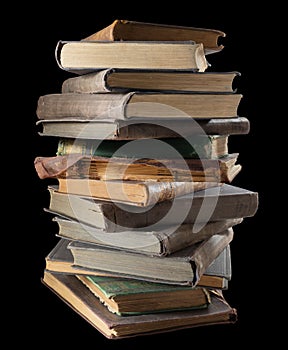 old books stacked one on top of another on a black background