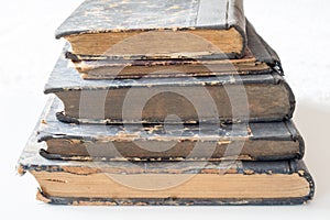 Old books stacked on a white table. Old release without titles.