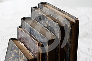 Old books stacked on a white table. Old release without titles.