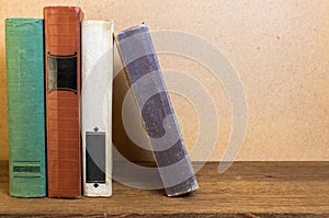 Old books stacked on a wooden shelf