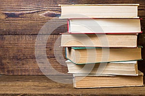 Old books stacked on a wooden shelf