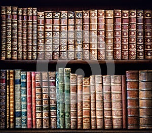 Old books on vintage wooden shelf.