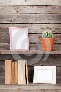 Old books and photo frames on a wooden shelf