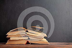 Old books on wooden table and blackboard