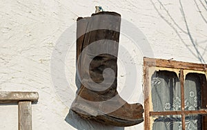 Old boots hang on the wall of a village house