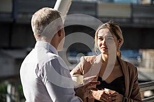 Old boss and business woman talk and drink coffee