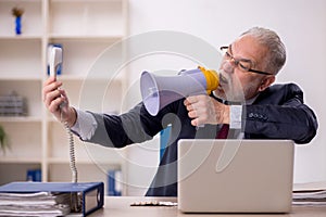 Old boss employee holding magaphone at workplace