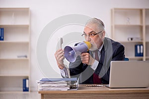 Old boss employee holding magaphone at workplace