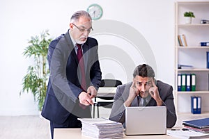 Old boss and his young assistant working in the office