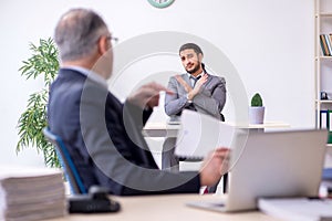 Old boss and his young assistant working in the office