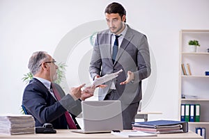 Old boss and his young assistant working in the office