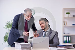 Old boss and his young assistant working in the office