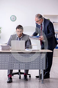 Old boss and his young assistant working in the office