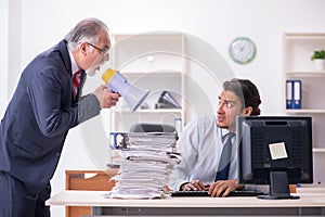 Old boss and young male employee in the office