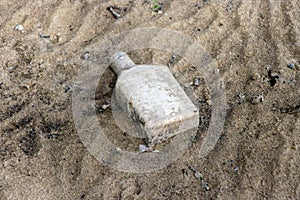 Old bottle buried in the mud of a dry lake bed