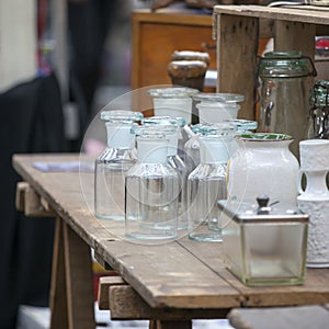 Old bottles and pharmacy jars on a wooden chest of drawers for sale