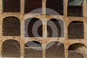 Old bottles of wine stacked in rows