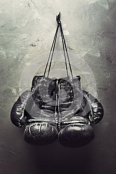 Old boxing gloves hang on nail photo
